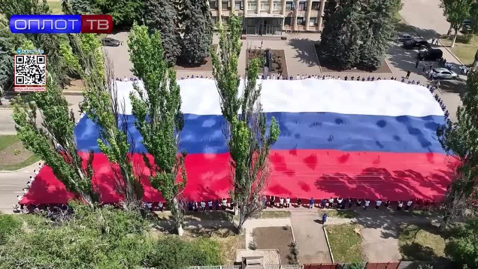 Огромный флаг России развернули в городах ДНР