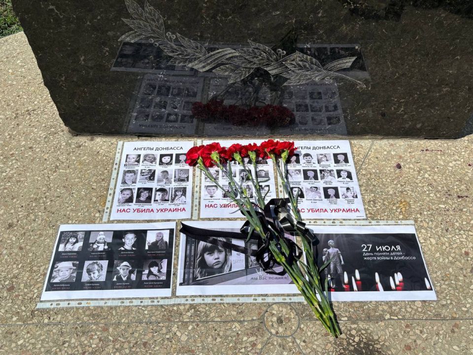 Партийцы Снежного несут цветы к памятному знаку в День памяти погибших детей Донбасса