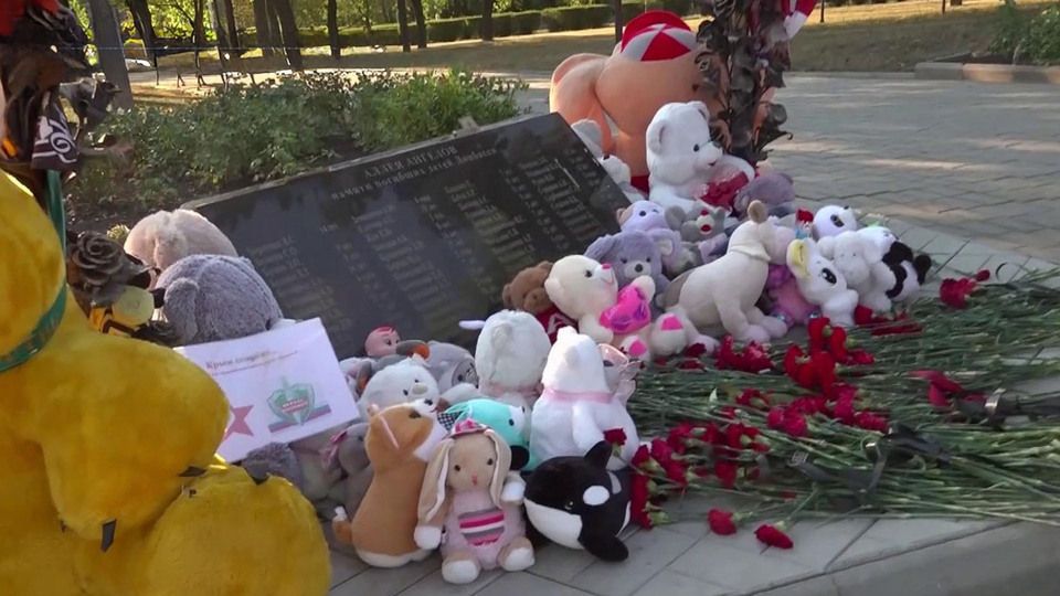 Люди несут цветы на Аллею ангелов в День памяти погибших детей Донбасса