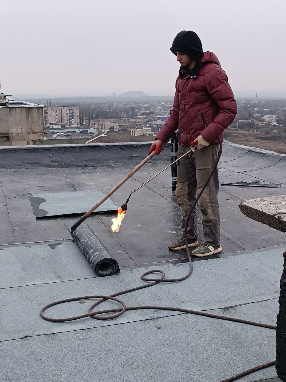 В микрорайоне Горняцком Кировского продолжается ремонт крыши дома № 14