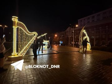 Даже дождь не останавливает дончан прогуливаться и фотографироваться у новогодних композиций на площади