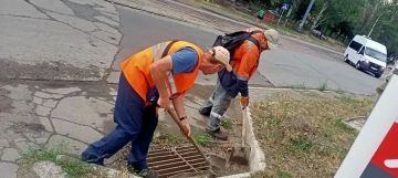 В Мариуполе дорожные рабочие прочищают колодцы ливневой канализации