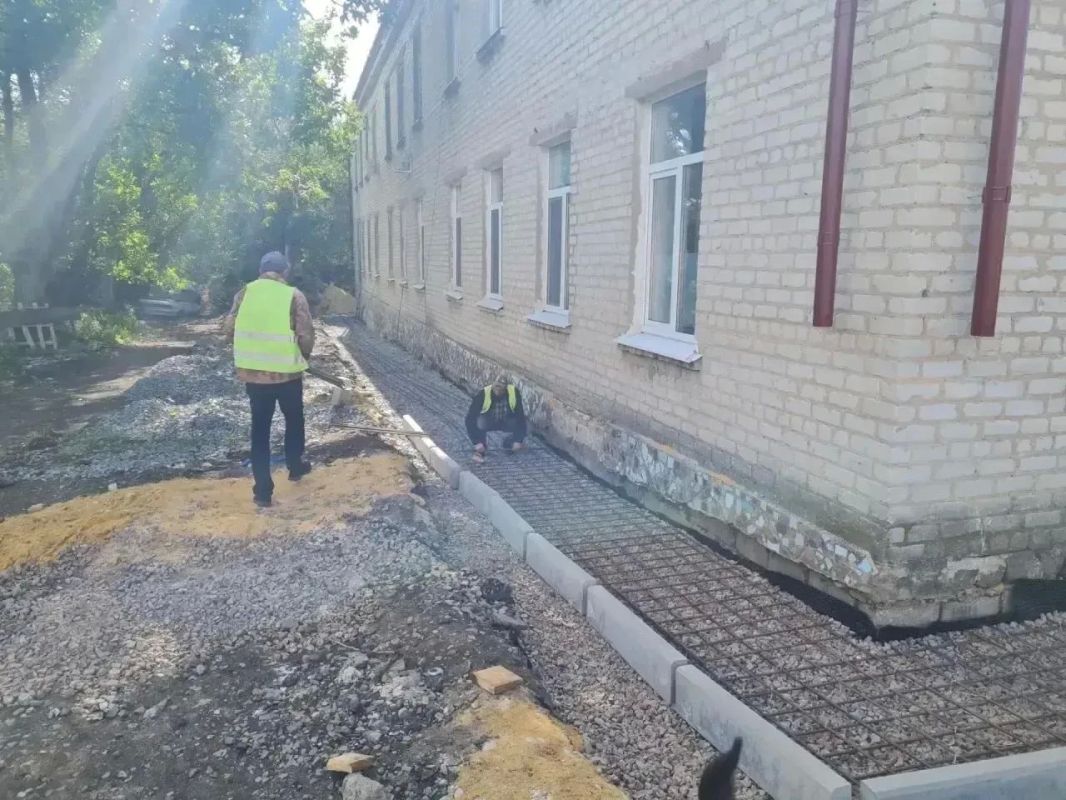 Самарские рабочие делают отмостку здания кожвендиспансера в Снежном